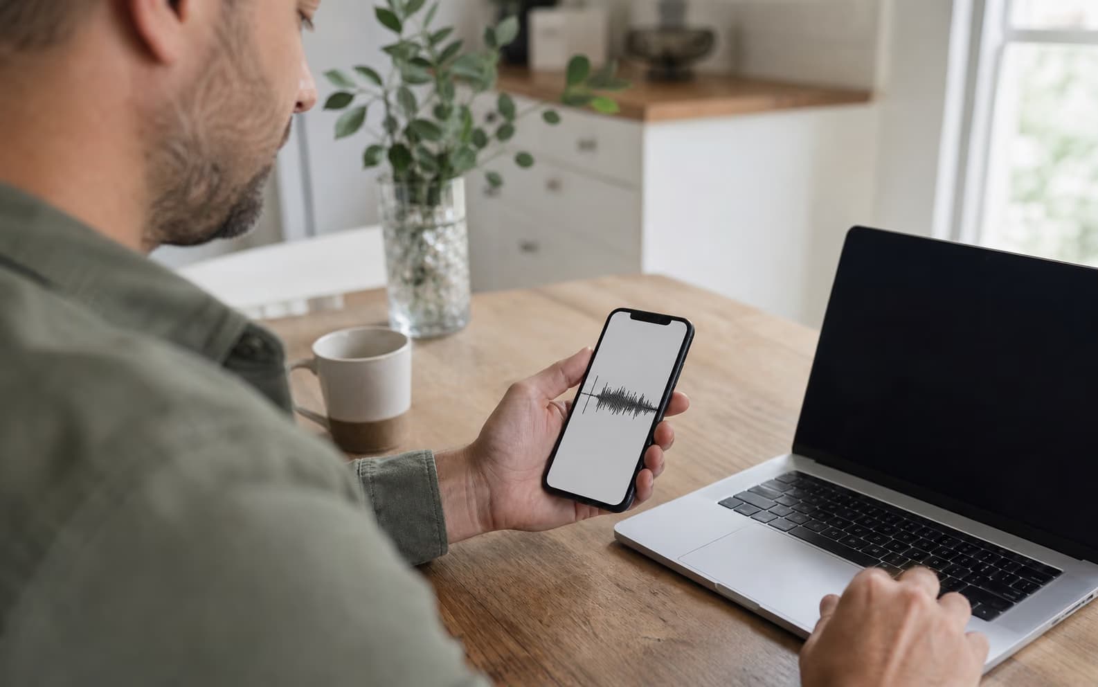 Person importing a smartphone voice memo into a laptop